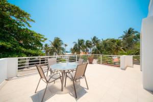 a patio with a table and chairs on a balcony at Villa Pura Vida - Spacious Oceanview with private pool - At Playacar Phase I in Playa del Carmen