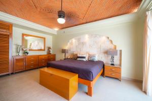 a bedroom with a large bed and a wooden ceiling at Villa Pura Vida - Spacious Oceanview with private pool - At Playacar Phase I in Playa del Carmen