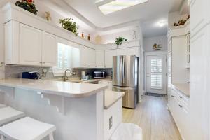 a kitchen with white cabinets and a stainless steel refrigerator at Cotton Candy in Destin