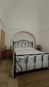 a bedroom with a large white bed with a black frame at LocoMura in Locorotondo