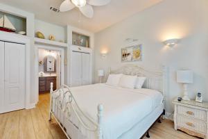 a bedroom with a white bed and a ceiling fan at Cotton Candy in Destin