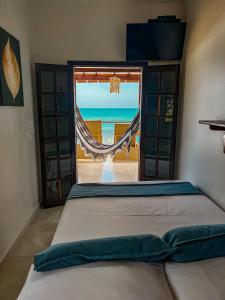 a bedroom with a bed with a view of the ocean at Hotel Garni Cruzeiro do Sul in Paraty