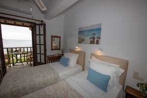 a bedroom with two beds and a view of the ocean at Lilian Beach Front 3 Skopelos in Panormos Skopelos