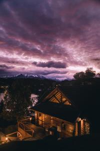 - Vistas nocturnas a una cabaña de madera con cielo púrpura en Marinas Alto Manzano en Villa La Angostura