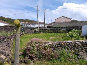een stenen muur met een houten paal en een hek bij Casa da Lapa in Angra do Heroísmo