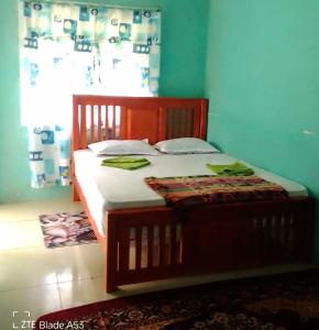 un letto in legno in una camera con finestra di kithulgala Green Rafting Hotel a Kitulgala