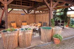 un patio con mesa, sillas y pérgola de madera en Gästewohnung am Sonnenstein en Brehme