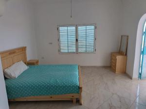 a bedroom with a bed and a window at Villa en el campo sobre el mar in Ras El Ma