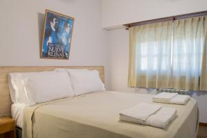 Un dormitorio con una cama con dos toallas encima. en Hotel de Cine Las Golondrinas, en Villa Gesell