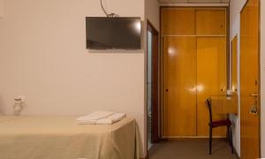 格塞尔镇拉斯格隆德里那斯的酒店的一间卧室，墙上有一张床和一台电视