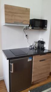 eine Küche mit schwarzer Arbeitsplatte und Mikrowelle in der Unterkunft Petit studio Magellan in Nantes