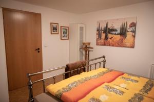 1 dormitorio con 1 cama con manta amarilla en Gästewohnung am Sonnenstein en Brehme