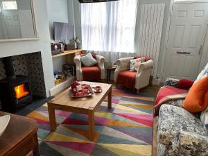 sala de estar con mesa de centro y chimenea en Artists’ Cottages, en Harrogate