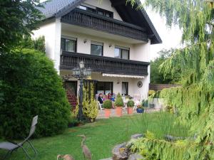grupa ludzi siedzących przed domem w obiekcie Haus Claudia w mieście Müllenbach +13 zdjęć