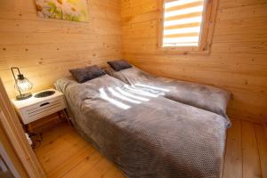 um quarto com uma cama grande num quarto de madeira em Domki letniskowe NIEZAPOMINAJKA Komańcza Letnisko em Komańcza