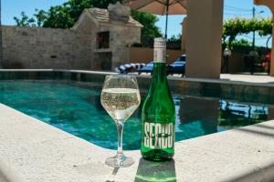 - une bouteille de vin et un verre à côté de la piscine dans l'établissement Villa Marta, à Mala Čista 49 autres photos