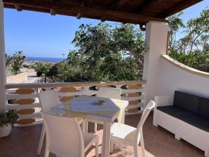 una mesa y sillas en un balcón con vistas al océano en Residence Villa Felice en Lampedusa