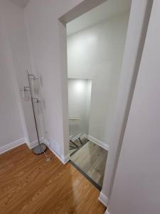 een lege kamer met witte muren en houten vloeren bij Cheerful 1 Bedroom Apartment with kitchennete in Ajax