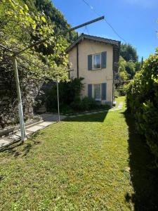 une maison dans une cour avec une pelouse dans l'établissement Casa Lilia, à Lugano