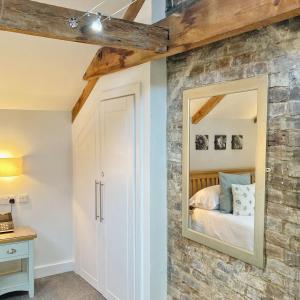 a bedroom with a stone wall and a mirror at The Britannia Inn & Waves Restaurant in Par