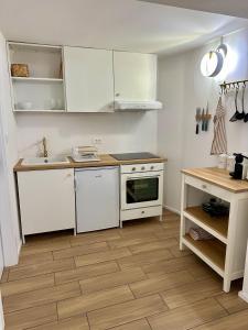 a kitchen with white cabinets and a wooden floor at Alpine Echo Apartments in Bovec