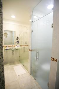 y baño con ducha acristalada y lavamanos. en Vert Motel Parnamirim en Parnamirim