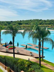 a swimming pool with palm trees in the foreground at Napo Luxury stay in Pretoria