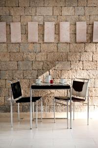 een tafel en stoelen voor een bakstenen muur bij Villa Santa Maria - Luxury Sea View Rooms in Amalfi