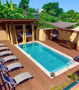 - une piscine avec des chaises sur une terrasse en bois dans l'établissement BaHaTi, à Saint-Pierre