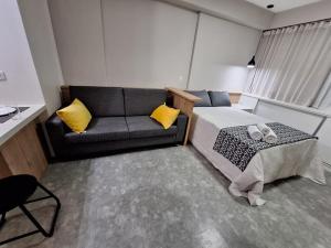 ein Schlafzimmer mit einem Bett und einem Sofa in der Unterkunft Life 914B · LiNDO Estúdio no Lifespace Wifi Ar e TV Smart in Curitiba