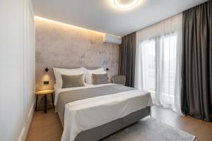 a bedroom with a large bed and a large window at Guesthouse Čivljak in Baška Voda