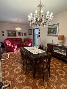 salon ze stołem, krzesłami i żyrandolem w obiekcie Villa Luisa w mieście Gorle