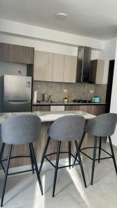 a kitchen with two bar stools and a counter at Moderno y acogedor apartamento in Santo Domingo