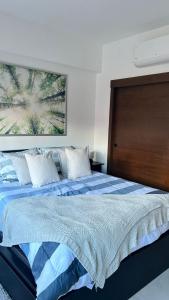 een slaapkamer met een bed met een groot schilderij aan de muur bij Moderno y acogedor apartamento in Santo Domingo