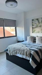 una camera da letto con un grande letto e una finestra di Moderno y acogedor apartamento a Santo Domingo