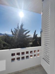a balcony with a window with the sun in the sky at Tarmaros Apartments in Sissi