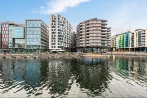 a city with tall buildings and a body of water at Exclusive sea-side apartment at Tjuvholmen - Oslo! in Oslo