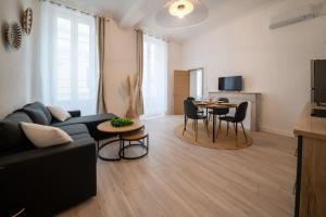 ein Wohnzimmer mit Sofa und Tisch in der Unterkunft Un Cocon Au Cœur d'Avignon Logement in Avignon