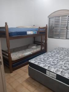 een kamer met 2 stapelbedden en een bed bij Condomínio Villagio Maranduba - Apenas 5 min á pé da praia - Bl 7 in Ubatuba