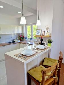 een keuken met een wit eiland met twee glazen wijn bij Serenity Apartment in Bitola