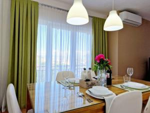 una sala da pranzo con tavolo, sedie e finestra di Serenity Apartment a Bitola