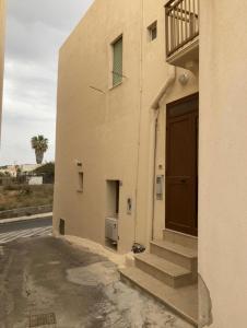ein Gebäude mit einer Tür neben einer Straße in der Unterkunft Appartamento Bent el Rhia in Pantelleria