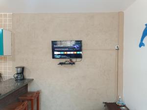 een flatscreen-tv aan een muur in een keuken bij Condomínio Villagio Maranduba - Apenas 5 min á pé da praia - Bl 7 in Ubatuba
