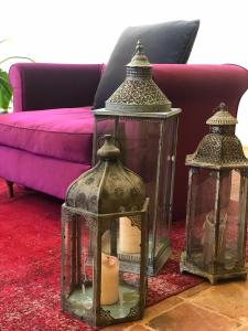 three glass lanterns on a red rug in front of a couch at La Cappella della Rotonda in Vicenza
