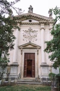 a large white building with a door and benches at La Cappella della Rotonda in Vicenza