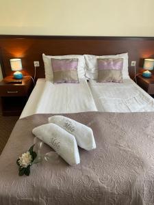 a large bed with two pillows and flowers on it at Villa Molo in Rewal