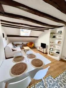 - un salon avec une table et des chaises blanches dans l'établissement Appartement cosy hypercentre, à Saumur