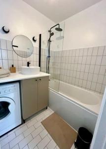 uma casa de banho com um lavatório e uma máquina de lavar roupa em Appartement cosy hypercentre Place St Pierre em Saumur
