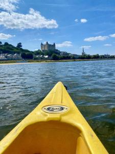 - un kayak jaune dans l'eau avec un château en arrière-plan dans l'établissement Appartement cosy hypercentre, à Saumur