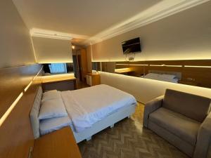 um quarto de hotel com uma cama, um sofá e uma televisão em Ayvacık Hotel Restaurant em Samsun